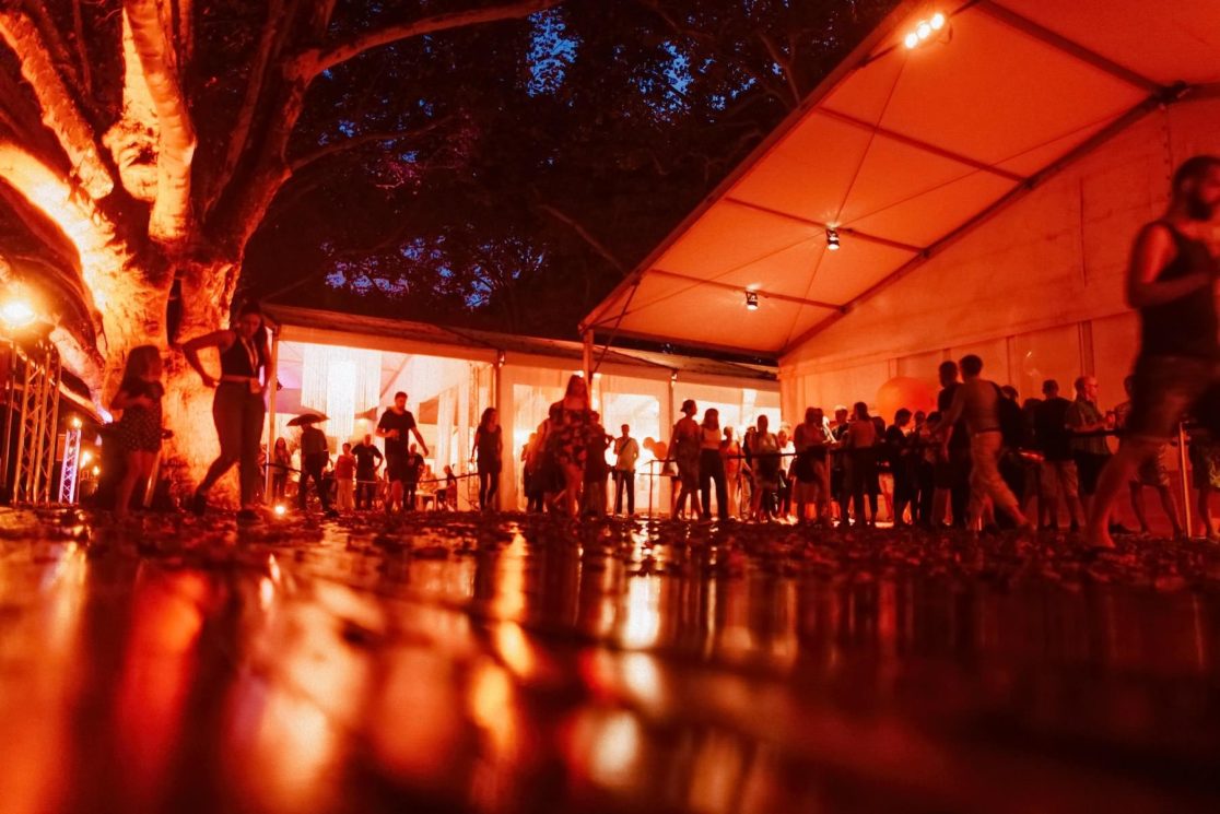 Besucher im Festivalzelt beim Festival des Deutschen Films Ludwigshafen im warmen Licht